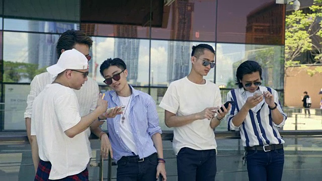年轻的亚洲成年男子在街上闲逛，看手机视频素材
