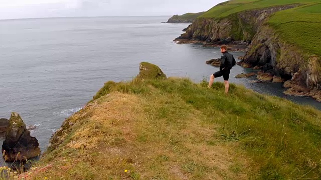 一个人站在悬崖上，手放在臀部4k视频素材