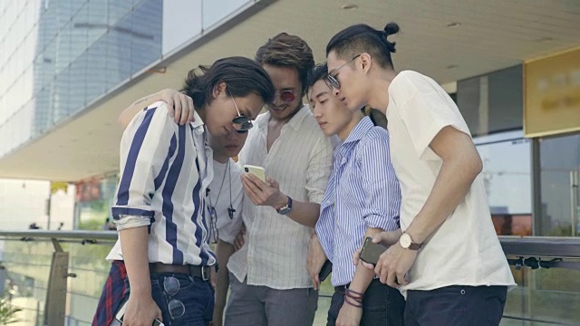 年轻的亚洲成年男子在街上闲逛，看手机视频素材