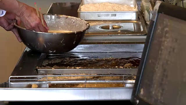 日本川口町，天妇罗厨师将生虾放入油炸锅中视频素材