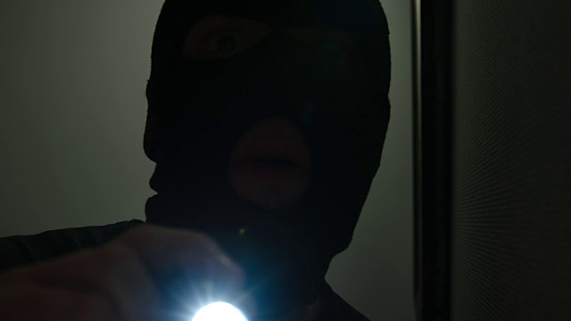 小偷爬进房子，用手电筒照了照照片和监控摄像头视频素材