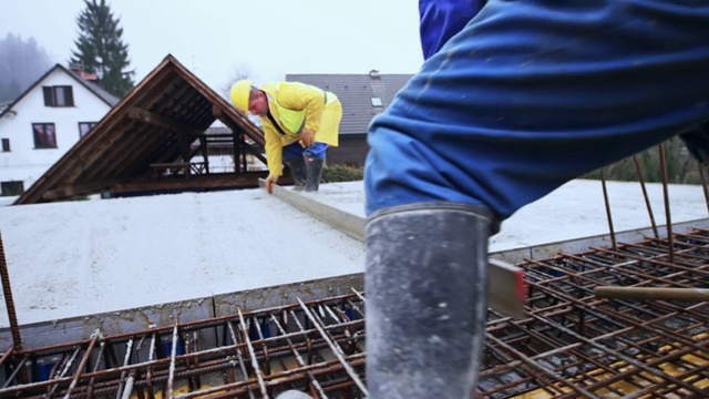 两名建筑工人浇筑混凝土后把大楼的地板弄平了视频素材