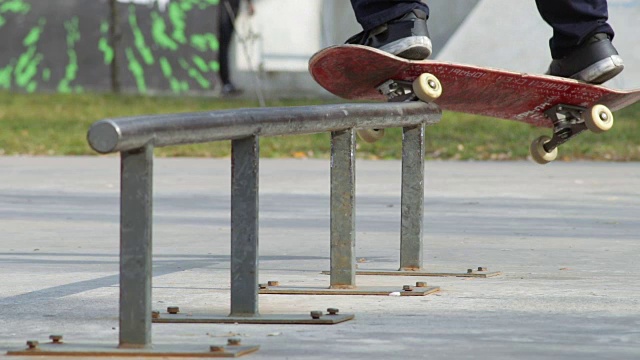 滑板手在滑板场的轨道上使研磨技巧变弱，慢动作的近景视频素材