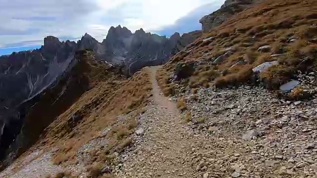 徒步旅行者走在意大利阿尔卑斯山陡峭的白云石山狭窄的小路上冒险徒步旅行。视频素材