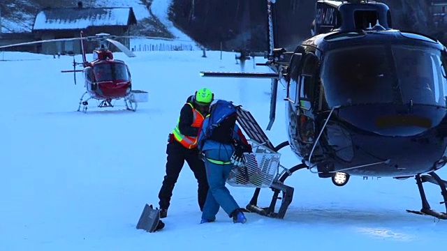 人们在装直升机准备在山上滑雪。——慢动作视频下载