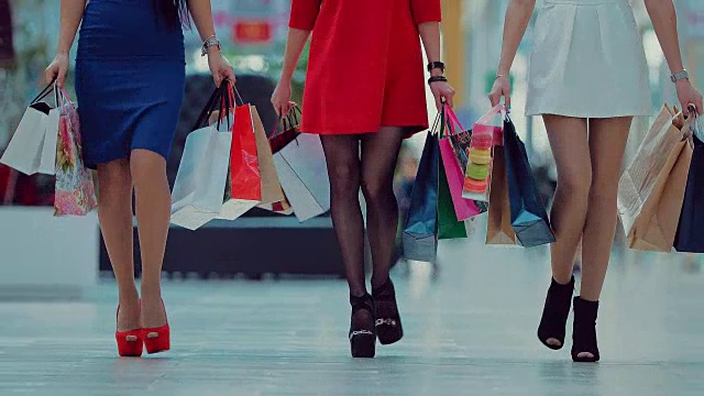 三个女孩穿着五颜六色的衣服在商场里走视频下载