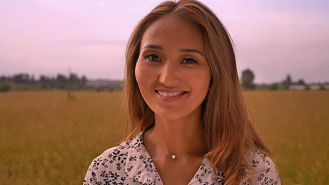 美丽的亚洲女人的肖像在麦田日落享受自然视频下载