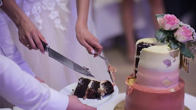 一个新娘和新郎切他们的婚礼蛋糕的特写。视频素材