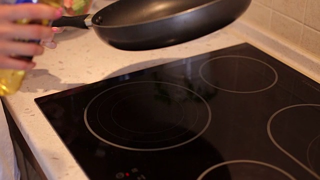厨师将植物油倒入锅中。将植物油倒入煎锅中。视频素材