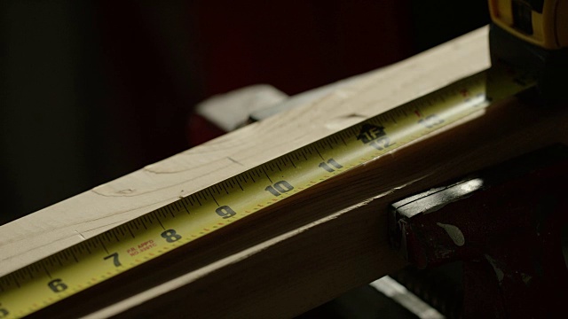 一个白人工匠用记号笔和卷尺在木板上做标记视频下载