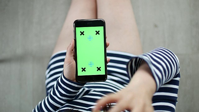 年轻女子使用绿色屏幕的智能手机的移动应用程序视频素材