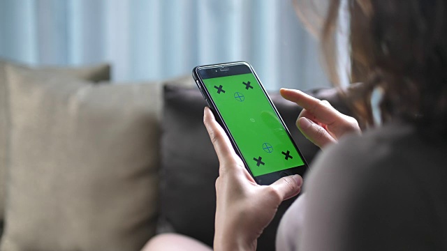 年轻女子使用绿色屏幕的智能手机的移动应用程序视频素材
