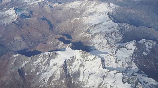 在秋天飞越欧洲阿尔卑斯山。冰川的景观。从飞机窗口鸟瞰图视频素材