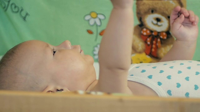 一个5个月大的婴儿躺在他的婴儿床上，正在做梦……视频素材