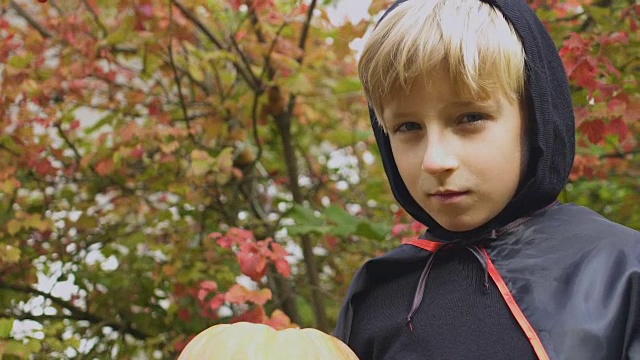 严肃的小男孩提着南瓜灯，可怕的万圣节派对，童年视频素材