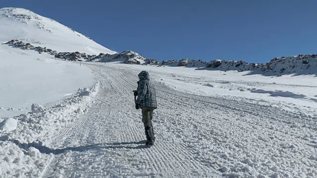 厄尔布鲁斯峰的全景图。少年爬上小路，拍下了相机。视频素材