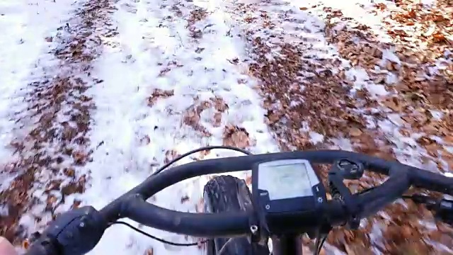 在雪覆盖的土路上骑山地自行车视频素材