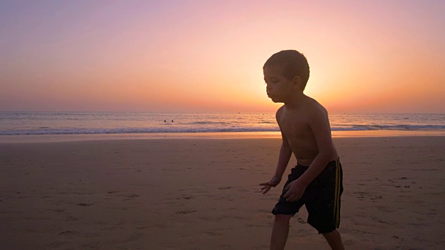 慢镜头-日落时分，孩子在沙滩上奔跑和玩耍的剪影视频素材