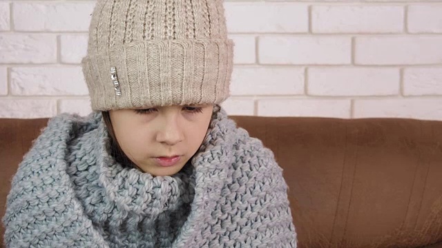 生病的孩子戴着暖和的帽子。视频素材