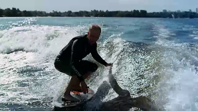 运动员用慢动作在波浪上冲浪。骑手做尾流冲浪特技视频素材