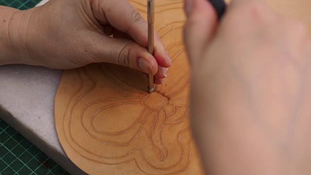 工匠邮票花在皮革上与斜角冲压工具和槌视频素材