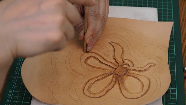 工匠印章浮雕的花在皮革上与斜角冲压工具视频素材
