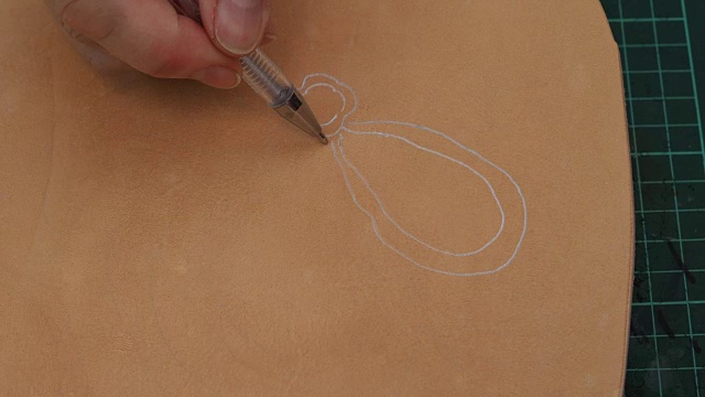 工匠在雕刻前先用笔在粗糙的皮革上画一幅花卉素描视频下载