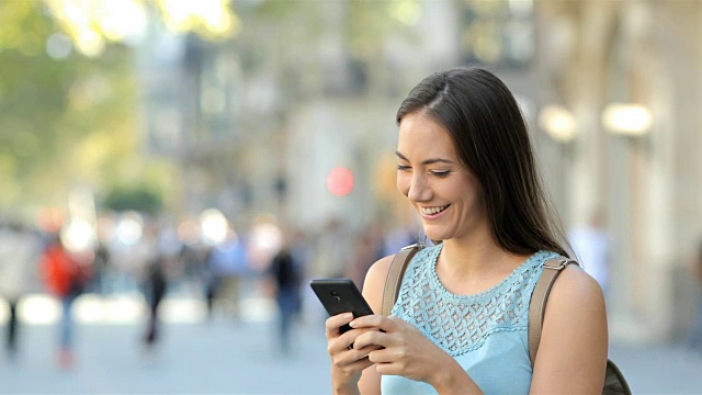 在街上浏览手机内容的女人视频素材