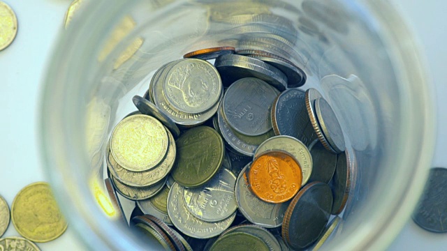 特写俯视图慢动作扔硬币泰国钱在罐子，概念储蓄视频素材
