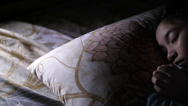 一个亚洲女孩睡在她的卧室里视频素材