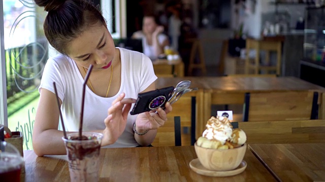 年轻女子用手机拍了一张冰淇淋的照片视频素材