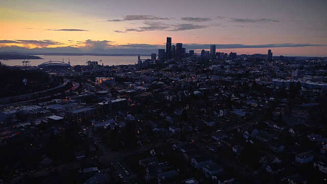 黑暗夜晚的城市景观与海滨日落空中视频素材