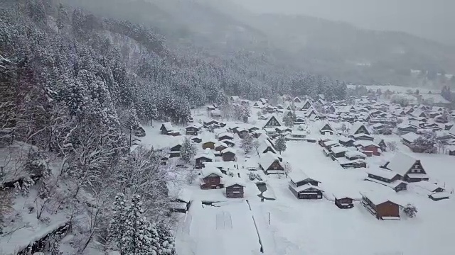 白川乡(Shirakawa-go)的传统茅草屋位于日本岐阜县(Gifu)、石川县(Ishikawa)和富山县(Toyama)附近的雪山中视频素材