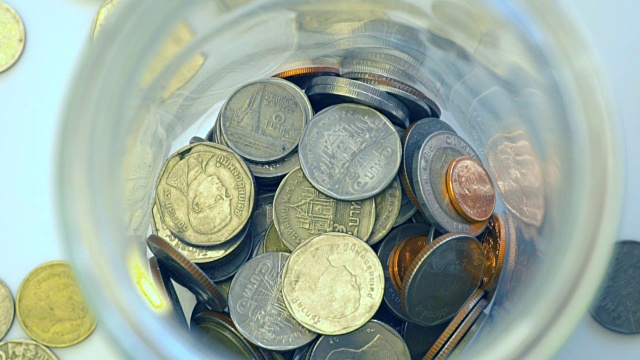 特写俯视图慢动作扔硬币泰国钱在罐子，概念储蓄视频素材