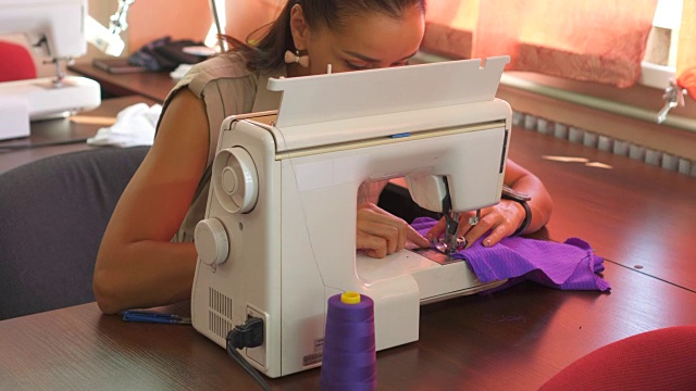 用缝纫机缝制布料的妇女视频下载