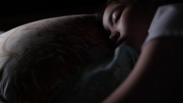 一个亚洲女孩睡在她的卧室里视频素材