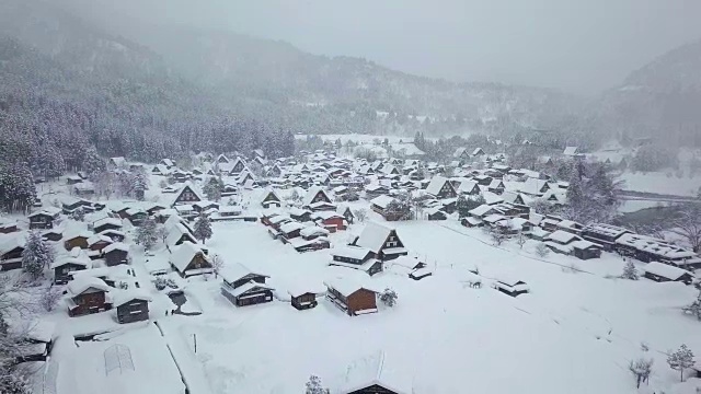 白川乡(Shirakawa-go)的传统茅草屋位于日本岐阜县(Gifu)、石川县(Ishikawa)和富山县(Toyama)附近的雪山中视频素材