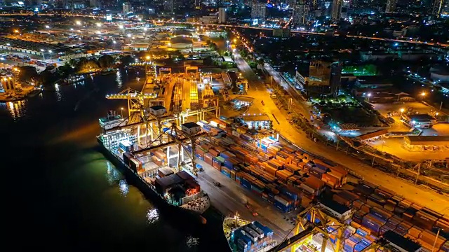 鸟瞰图无人机延时或延时拍摄的工业港口或造船厂与集装箱船在晚上在东南亚视频素材