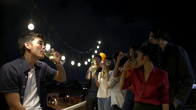 一群年轻的朋友跳舞和有乐趣庆祝新年和圣诞节一起在夏天的屋顶派对。缓慢的运动。视频购买
