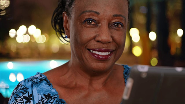 年长的非洲裔美国妇女使用数码平板电脑对着相机微笑视频下载
