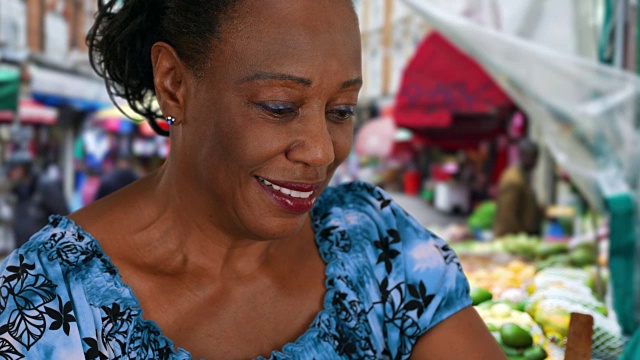 在布里克斯顿的食品市场用智能手机发短信的高级非洲裔美国妇女视频下载