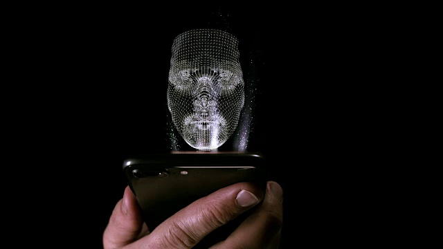 一名男性手持智能手机，屏幕上投射着面部全息图视频下载