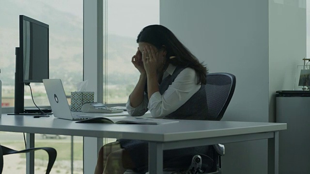 美国犹他州Pleasant Grove办公室疲惫的女商人使用笔记本电脑的镜头视频素材