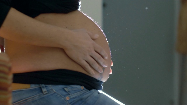 孕妇爱抚着自己的肚子——母亲，新生儿——慢动作视频素材