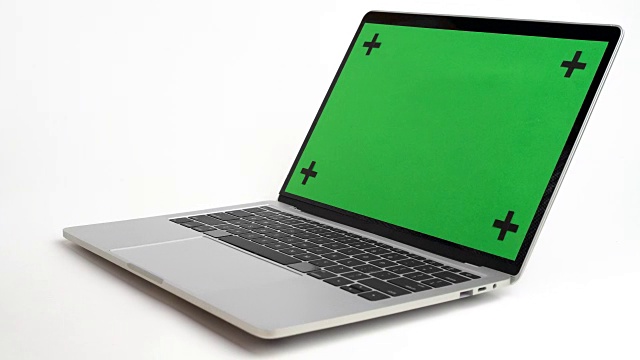 笔记本电脑与绿色屏幕旋转白色背景。视频下载