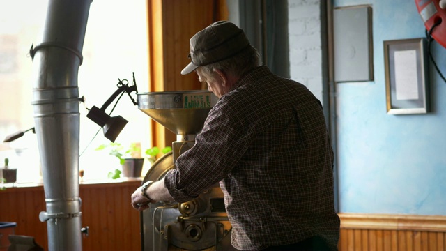 咖啡烘焙师在烘焙机上工作。视频下载
