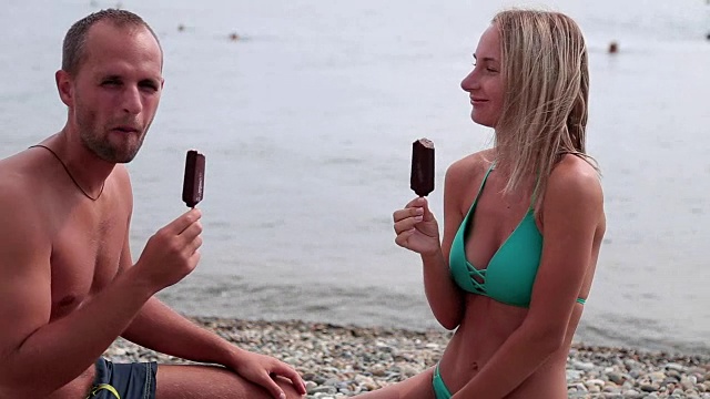 年轻夫妇在海滩上吃冰淇淋视频下载