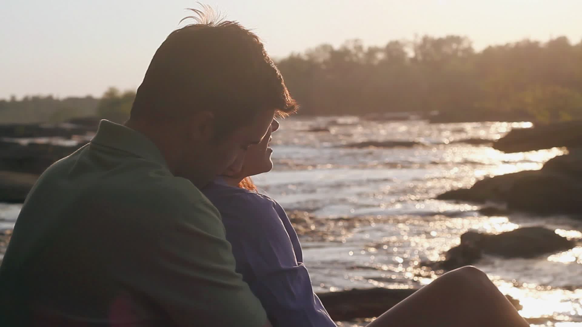 黄昏时分，美国弗吉尼亚州里士满的河岸上，一对情侣拥抱亲吻视频下载