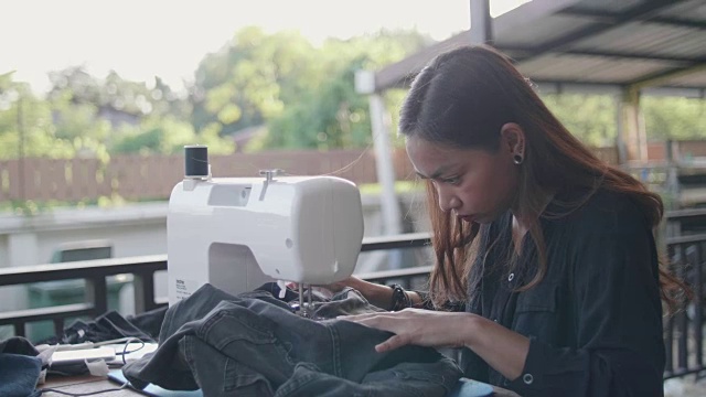 年轻女子在家里用缝纫机视频素材