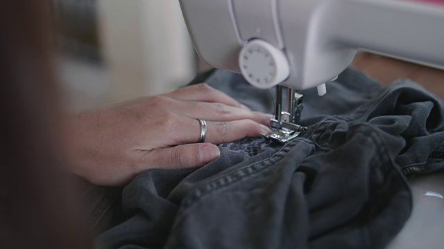 年轻的亚洲女裁缝在缝纫机上工作。视频素材